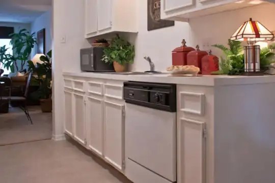 bar featuring carpet, dishwasher, light floors, light countertops, and white cabinetry