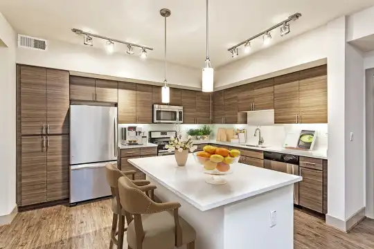 kitchen featuring stainless steel appliances, range oven, light floors, pendant lighting, dark brown cabinetry, and light countertops