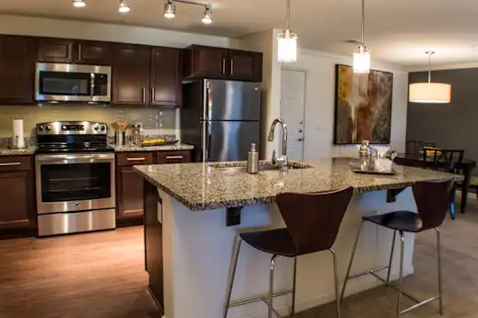 kitchen with electric range oven, stainless steel appliances, granite-like countertops, light flooring, dark brown cabinets, and pendant lighting