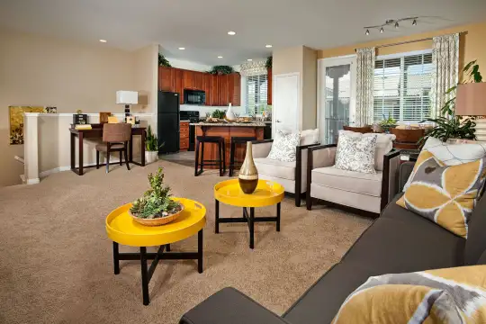 carpeted living room with a breakfast bar area, refrigerator, and microwave