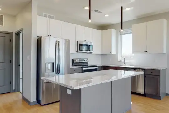 kitchen featuring a center island, natural light, stainless steel appliances, range oven, white cabinets, pendant lighting, light stone countertops, and light parquet floors