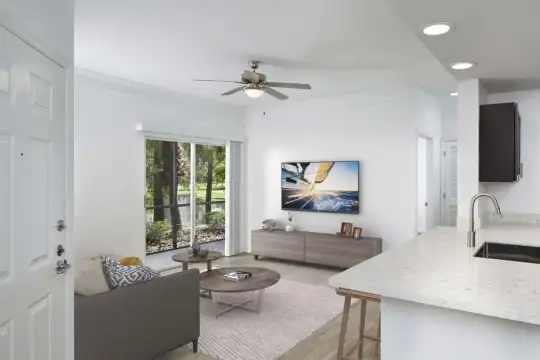 living room with a ceiling fan, a breakfast bar, natural light, and TV