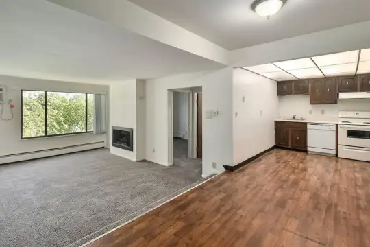 kitchen with natural light, baseboard radiator, range oven, dishwasher, extractor fan, dark brown cabinets, light parquet floors, and light countertops