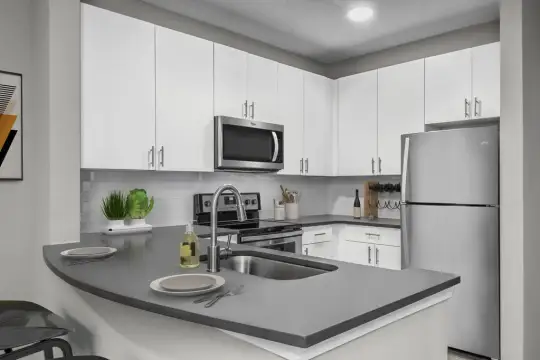 kitchen featuring stainless steel appliances, electric range oven, white cabinetry, and light floors