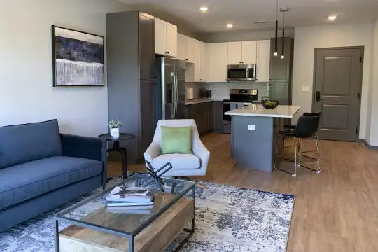 living room featuring a breakfast bar, stainless steel microwave, refrigerator, and range oven