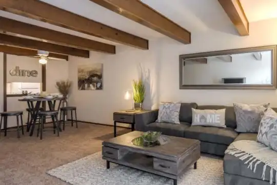 living room with wood beam ceiling and carpet