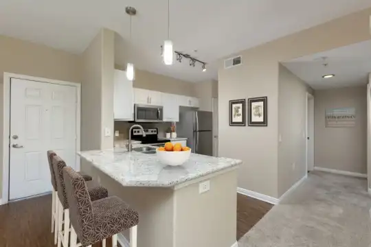 kitchen with a kitchen island, a kitchen bar, stainless steel appliances, range oven, pendant lighting, white cabinets, light granite-like countertops, and light parquet floors