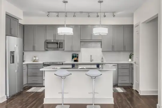 kitchen with a kitchen island, stainless steel appliances, range oven, white cabinets, dark parquet floors, light countertops, and pendant lighting