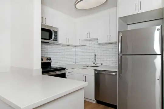 kitchen featuring electric range oven, stainless steel appliances, light flooring, light countertops, and white cabinets
