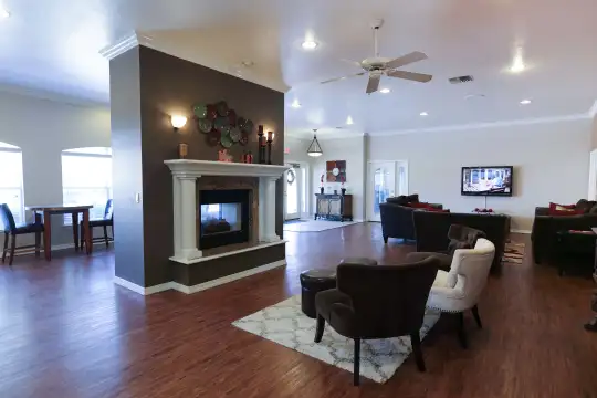 hardwood floored living room featuring a ceiling fan, a fireplace, and TV