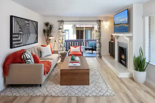 hardwood floored living room with a fireplace and TV