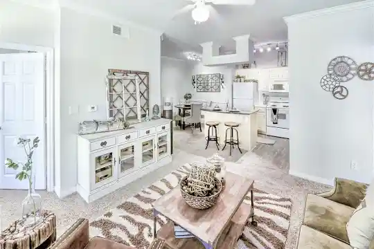 living room with a breakfast bar, a ceiling fan, refrigerator, range oven, and microwave