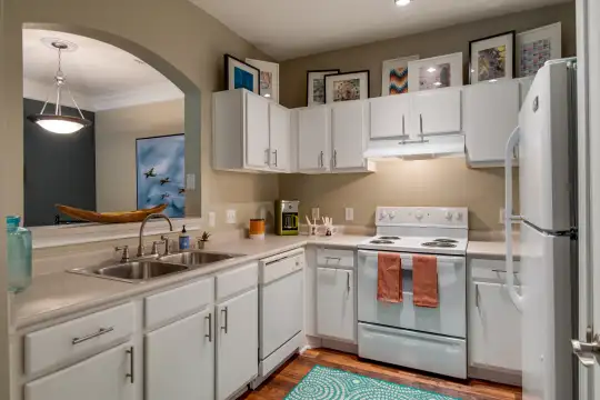 kitchen with refrigerator, dishwasher, ventilation hood, electric range oven, pendant lighting, white cabinets, light parquet floors, and light countertops