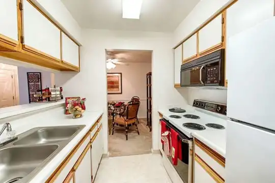 kitchen featuring refrigerator, electric range oven, microwave, white cabinets, light countertops, and light tile floors