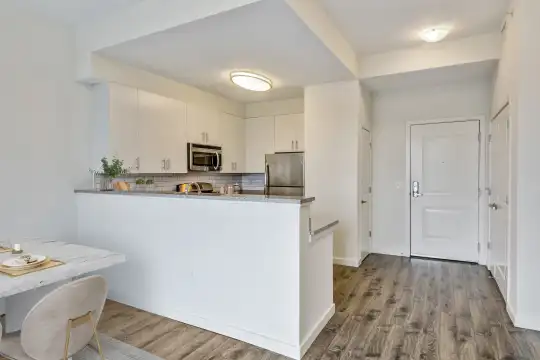 kitchen featuring stainless steel appliances, white cabinets, and light hardwood flooring