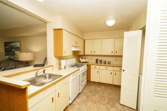 kitchen featuring gas range oven, dishwasher, fume extractor, light tile flooring, white cabinets, and light countertops