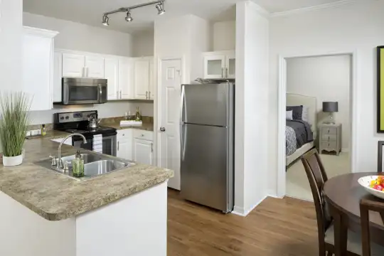 kitchen featuring electric range oven, stainless steel appliances, granite-like countertops, white cabinets, and light hardwood floors
