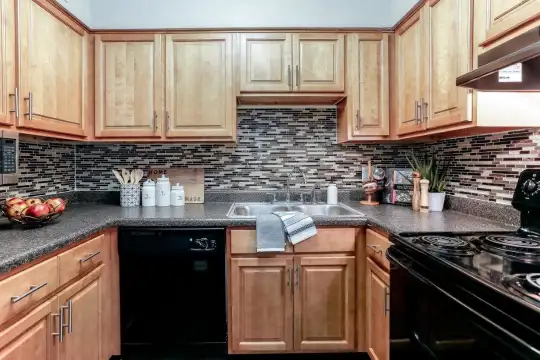 kitchen with range hood, dishwasher, electric range oven, and brown cabinets