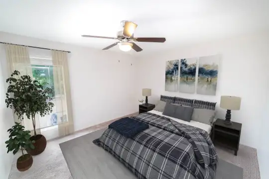 carpeted bedroom with a ceiling fan and natural light