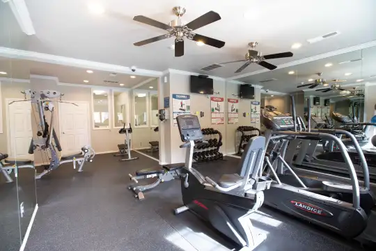 gym with a ceiling fan and TV