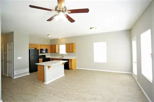 kitchen featuring natural light, a ceiling fan, refrigerator, microwave, dishwasher, range oven, light parquet floors, brown cabinets, and light countertops