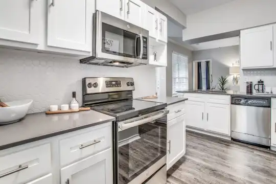kitchen with stainless steel appliances, electric range oven, light parquet floors, and white cabinets