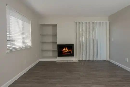 hardwood floored living room with natural light and a fireplace