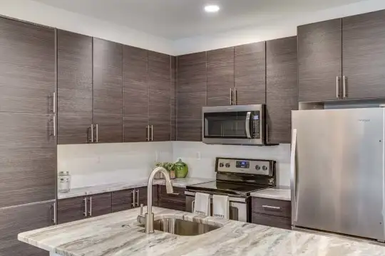 kitchen featuring stainless steel appliances, electric range oven, dark brown cabinetry, and light granite-like countertops