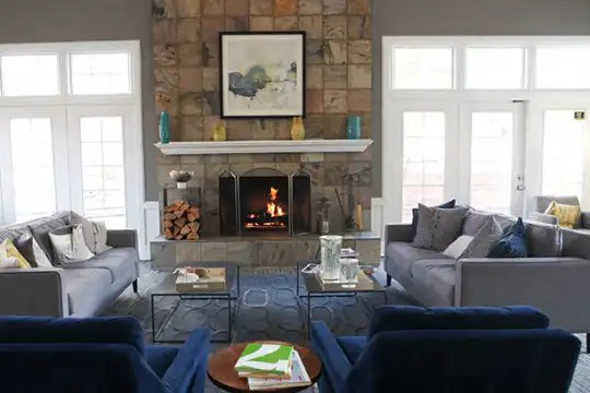 living room with a wealth of natural light, a high ceiling, and a fireplace