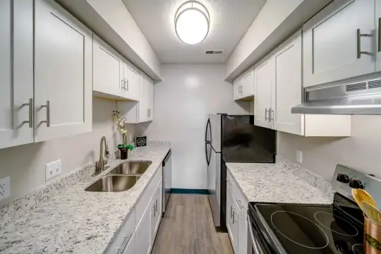kitchen featuring ventilation hood, refrigerator, dishwasher, white cabinetry, light hardwood floors, pendant lighting, and light stone countertops