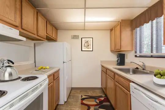 kitchen with ventilation hood, refrigerator, dishwasher, light countertops, dark tile flooring, and brown cabinets