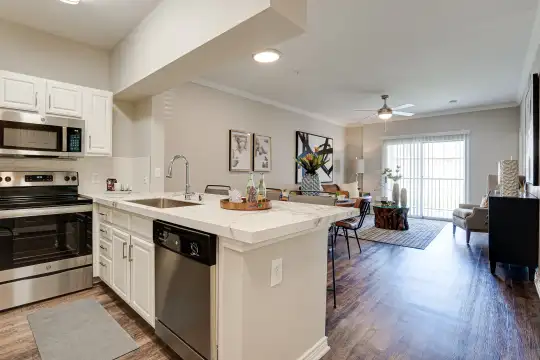 kitchen featuring a ceiling fan, a kitchen island, natural light, electric range oven, stainless steel appliances, white cabinets, light countertops, pendant lighting, and light parquet floors