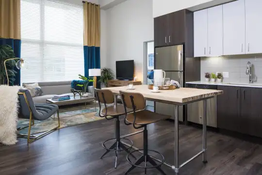 kitchen featuring natural light, stainless steel appliances, TV, dark hardwood flooring, dark brown cabinets, and light countertops