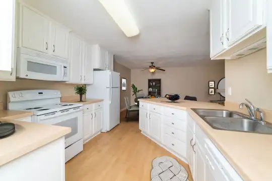 kitchen with a ceiling fan, refrigerator, dishwasher, electric range oven, microwave, white cabinetry, light parquet floors, and light countertops