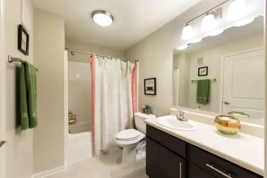 full bathroom featuring tile floors, mirror, toilet, shower / bathing tub combination, vanity, and shower curtain
