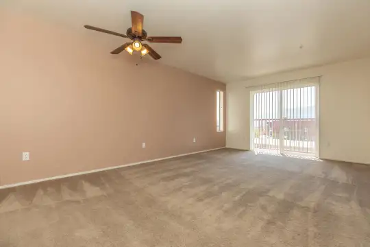carpeted empty room featuring a ceiling fan and natural light
