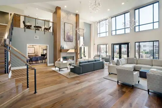 living room with a fireplace, a high ceiling, plenty of natural light, parquet floors, and a chandelier