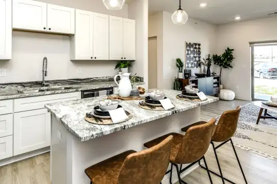 kitchen featuring natural light, granite-like countertops, light hardwood flooring, pendant lighting, and white cabinetry