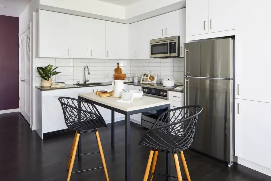 kitchen featuring stainless steel appliances, range oven, dark parquet floors, and white cabinets