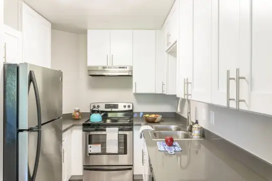 kitchen featuring electric range oven, stainless steel refrigerator, exhaust hood, dark countertops, and white cabinetry