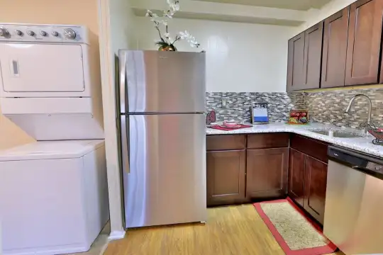 laundry area featuring hardwood flooring, stainless steel appliances, and washer / dryer