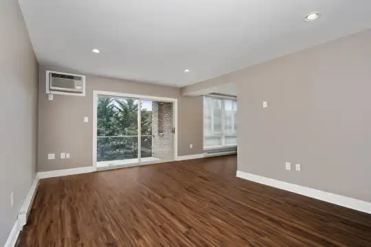 empty room with hardwood flooring and a healthy amount of sunlight