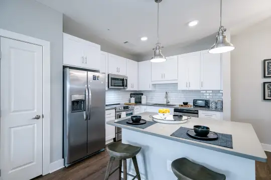 kitchen featuring stainless steel appliances, range oven, white cabinetry, pendant lighting, and dark hardwood floors