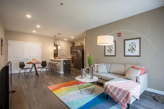 living room featuring a kitchen breakfast bar, hardwood flooring, refrigerator, and TV