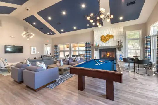 game room featuring a notable chandelier, hardwood flooring, a fireplace, natural light, and TV