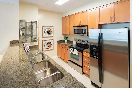 kitchen with stainless steel appliances, electric range oven, dark granite-like countertops, and brown cabinets