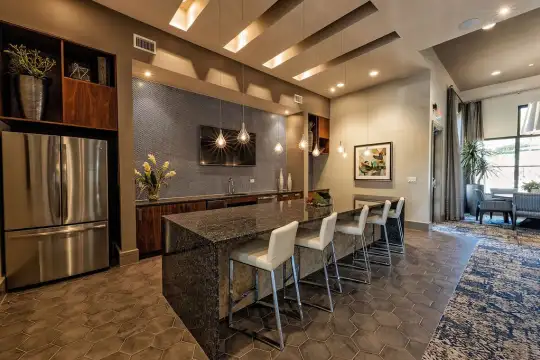 bar featuring a kitchen bar, stainless steel refrigerator, TV, dark flooring, pendant lighting, dark granite-like countertops, and dark brown cabinets