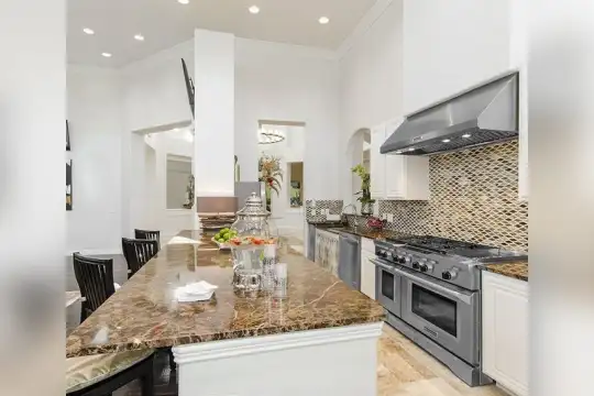 kitchen with a kitchen island, gas range oven, dishwasher, range hood, white cabinets, dark granite-like countertops, and dark hardwood floors