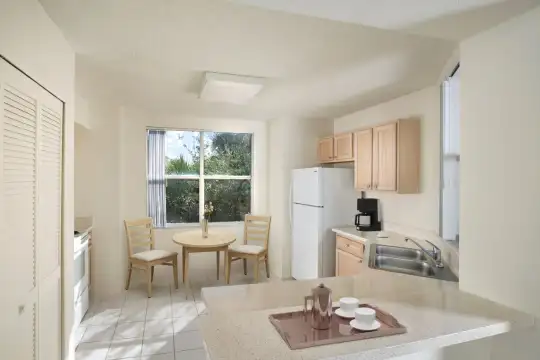 kitchen featuring natural light, tile flooring, refrigerator, range oven, light brown cabinets, and light countertops