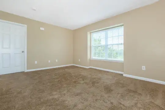 carpeted empty room with natural light